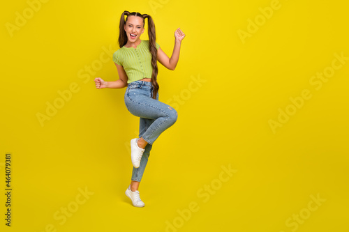 Full length body size view of attractive cheerful long-haired girl dancing rejoicing isolated over bright yellow color background