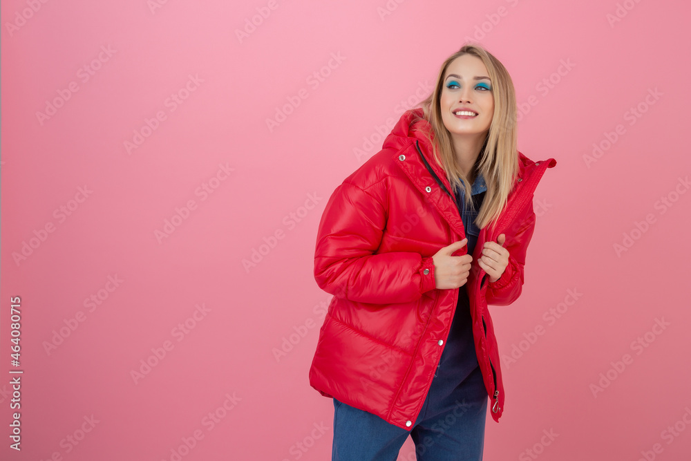 blond happy attractive active woman posing on pink background in colorful winter down jacket of red color, having fun, warm coat fashion trend, smiling blond happy attractive active woman posing on pink background in colorful winter down jacket of red color, having fun, warm coat fashion trend, smiling