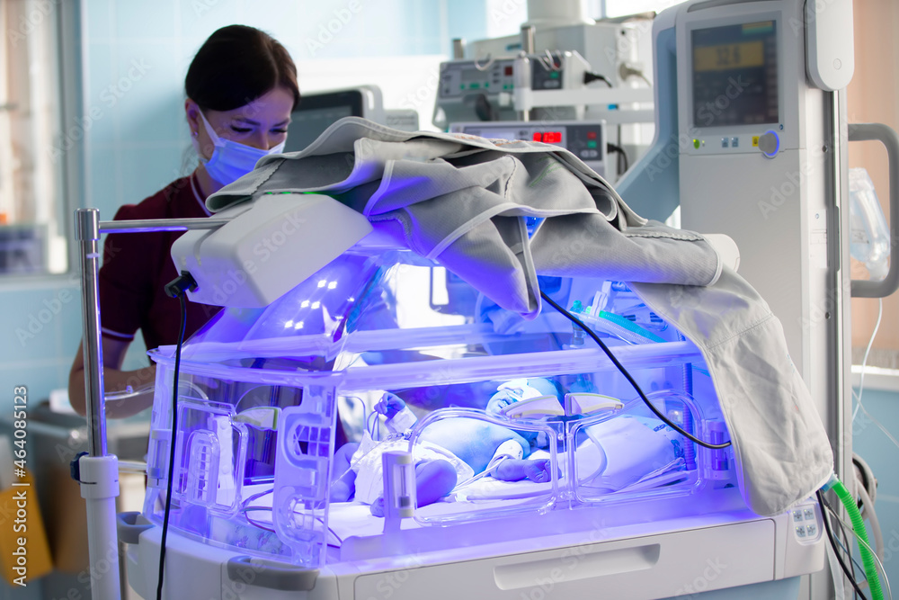 Foto Stock A newborn baby is treated for jaundice under ultraviolet