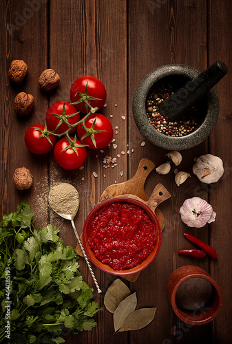 Georgian cuisine dish, tomato sauce Satsebeli, on a wooden table, top view, vintage style, no people,