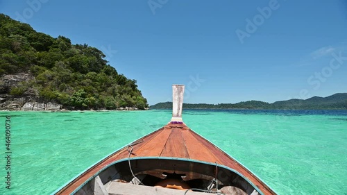 Wooden long-tail boat sailing on emerald tropical sea at lipe island photo
