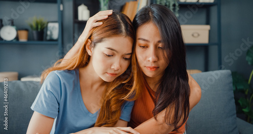 Asian women teenager embracing to calm her sad best friends from feeling down from breakup with boyfriend in living room at home. Friendship counseling and care, unhappy girl support her girlfriend. © tirachard