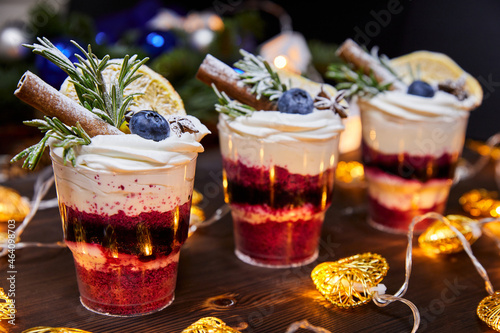 Photos Christmas trifles in cups as a dessert, decorated with fresh blueberries and a v