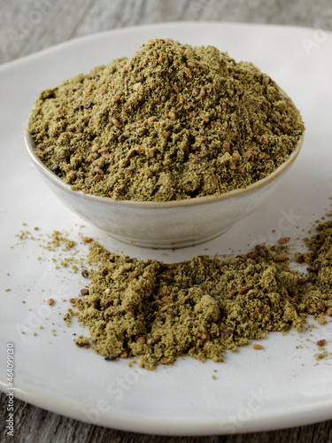 Green Za'atar spice blend heap in a bowl. Traditional Middle East zaatar condiment. photo