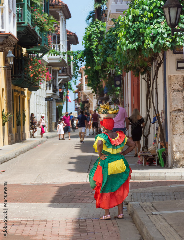 Naklejka premium Woman dressing with vivid colours in the corner of street of the walled city