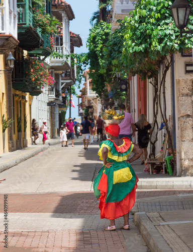 Woman dressing with vivid colours in the corner of  street of the walled city photo