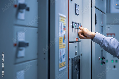 Electrical engineer push red button for check load center cabinet or consumer unit for maintenance in main power distribution system room.