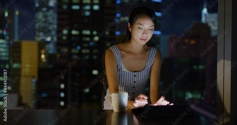 Woman work on tablet computer at room in the evening