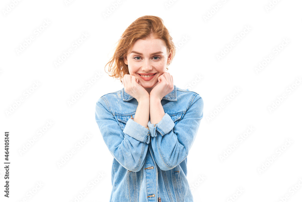Portrait of a young red-haired girl on a white isolated background in jeans. Looks into the camera Portrait of a young red-haired girl on a white isolated background in jeans. Looks into the camera