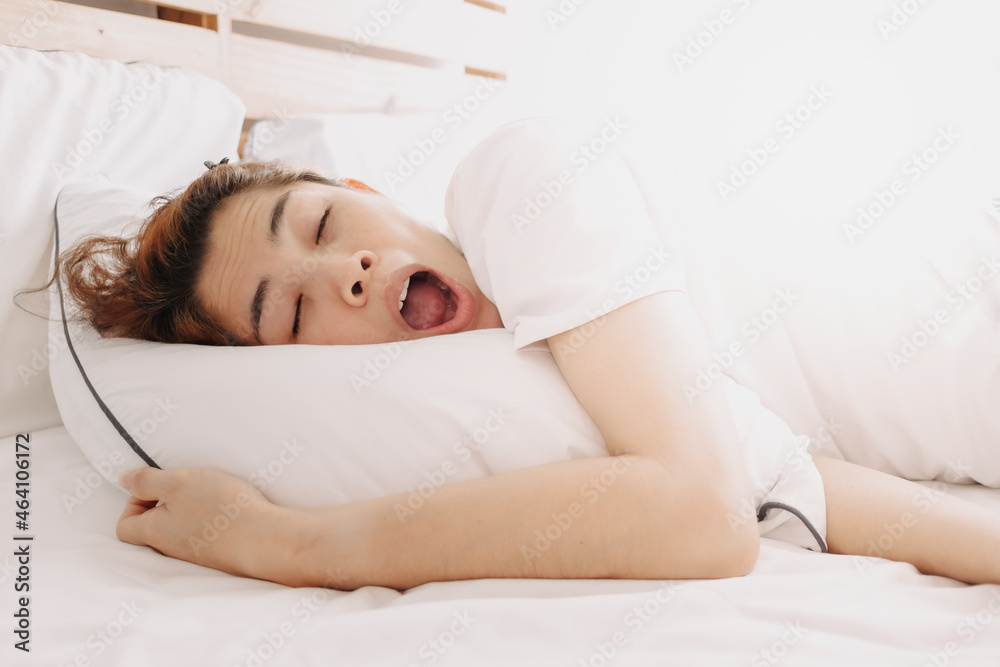 Funny sleepy yawning Asian woman just wake up on her bed. Funny sleepy yawning Asian woman just wake up on her bed.