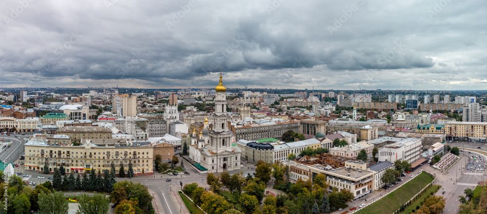 City aerial panorama, autumn Dormition Cathedral between Konstytutsii and Pavlivska Squares, streets with gray heavy clouds in Kharkiv, Ukraine