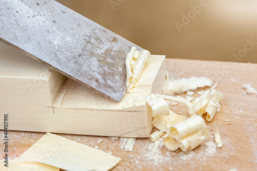 Handmade wooden furniture. A chisel removes shavings from a board, close-up.