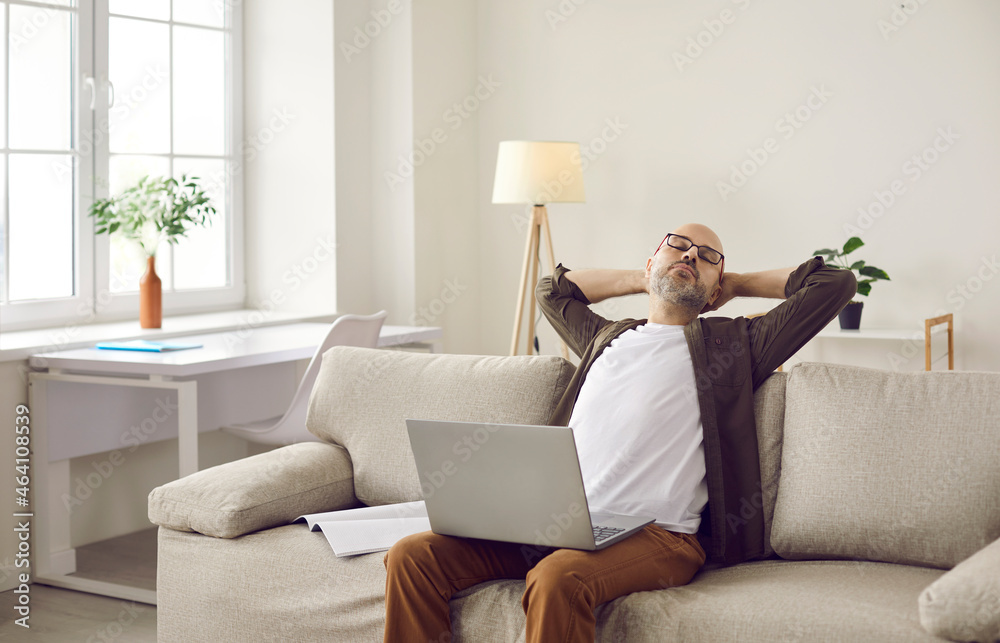 Tired man employee worker fall asleep on sofa working online on laptop at home. Exhausted middle-aged male doze sleep on couch in living room, distracted from computer job. Overwork concept. Tired man employee worker fall asleep on sofa working online on laptop at home. Exhausted middle-aged male doze sleep on couch in living room, distracted from computer job. Overwork concept.