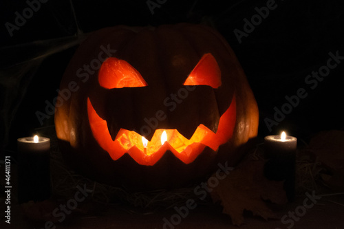 Halloween scary pumpkin with a burning candles. Dark background