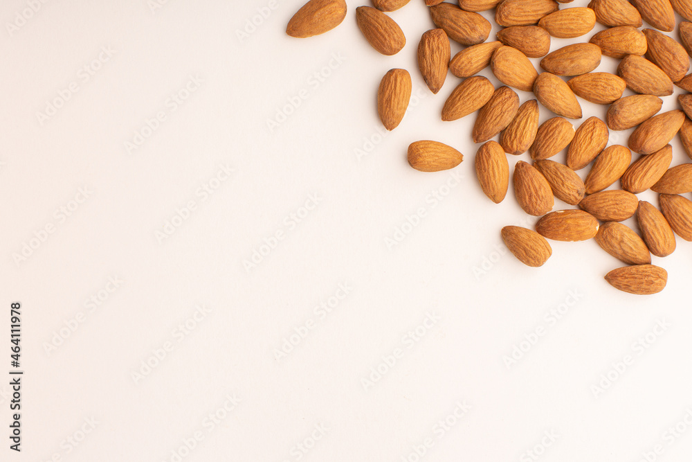 Almond pattern on beige background, top view with copy space