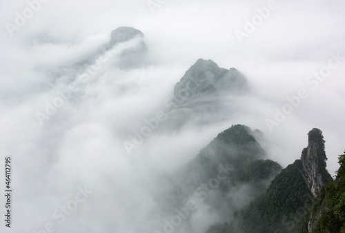 Aerial landscape image of mountaintops shrouded in white clouds.