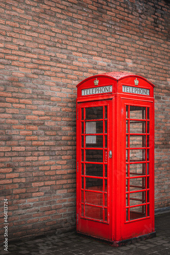 The traditional British public red telephone kiosk or booth with brick wall in the background, Bushmills town, Northern Ireland