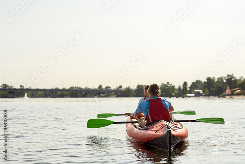 Young european family floats on kayak at sunny day