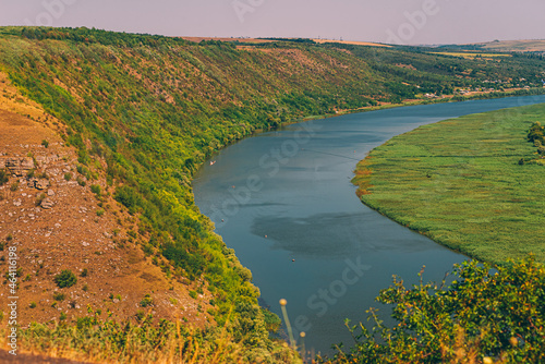 Aerial photo a a river between a beautiful field and hill.