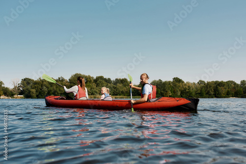 Young european family floats on kayak in lake