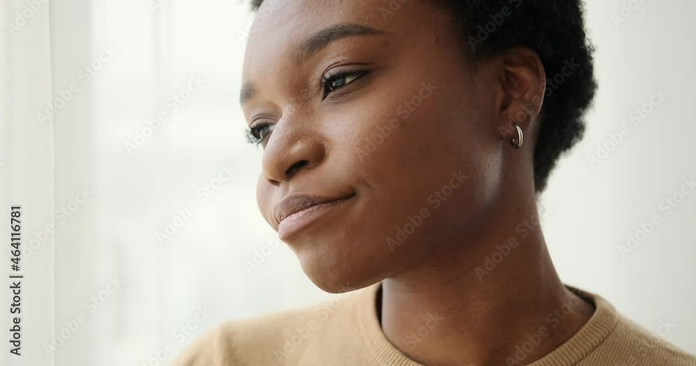 Sad woman looking out through window at home Sad woman looking out through window at home