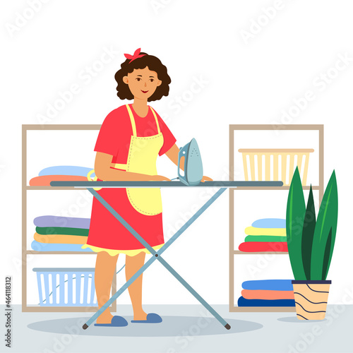 Happy housewife ironing linen with an iron on an ironing board