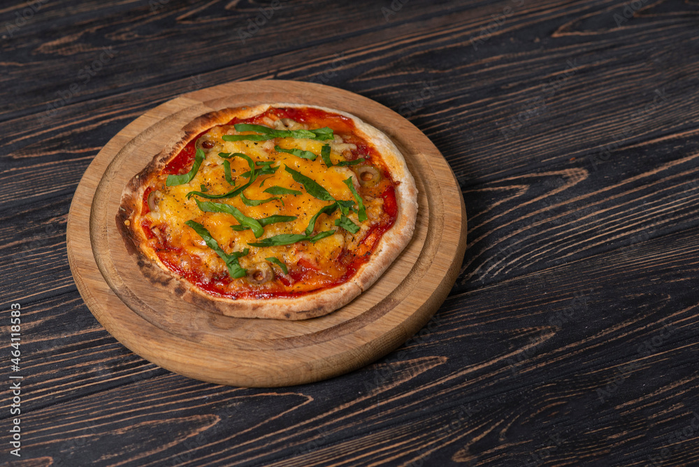 Homemade baked pizza on yeast-free dough with cheese, tomato and salami. A simple and quick recipe for home cooking. Served on wooden plank. Brown wood background, copy space