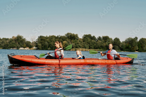 Beautiful family floats on kayak in lake or river