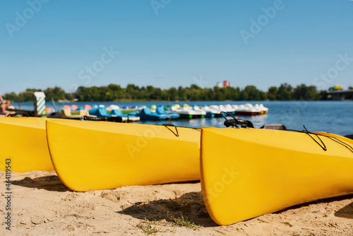 Collection of kayaks in row on sandy coast