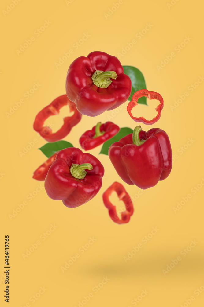 Creative food or vegetables concept. Fresh whole and sliced red bell  peppers flying in air isolated on pastel yellow background. Stock Photo |  Adobe Stock