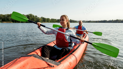 European family floats on canoe boat in river