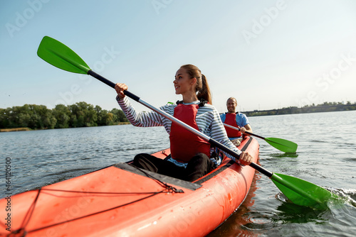 Beautiful family floats on canoe boat in lake