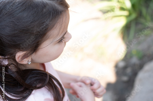 Little beautiful girl with pigtails smiling on a blurred background. Top and side view Photo