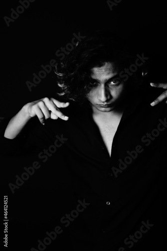 Принти на полотні Portrait of a young South Asian male model with long hair on a black background