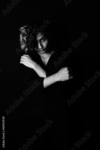 Принти на полотні Portrait of a young South Asian male model with long hair on a black background