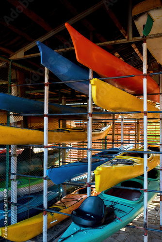 Different colorful kayaks on shelves in storage