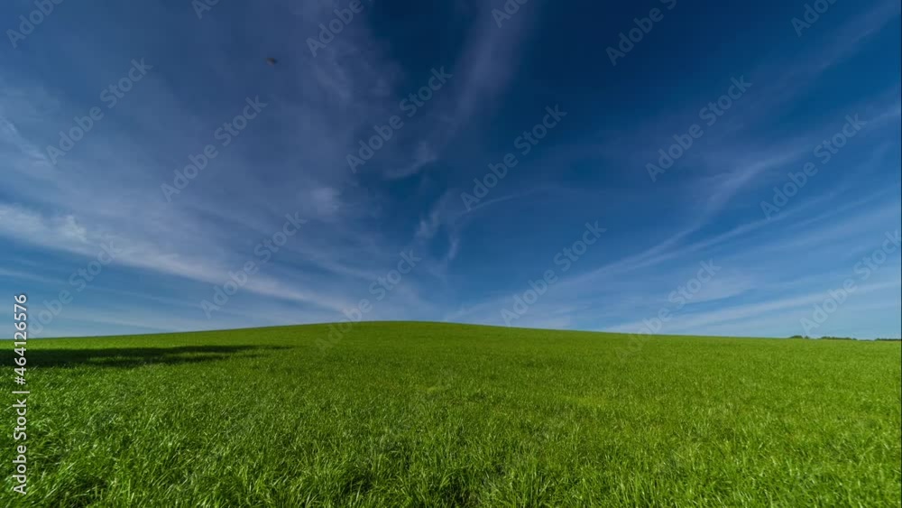 Zeitraffer - streifende Wolken über grüne Landschaft