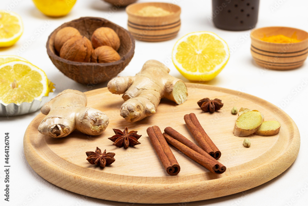 Cinnamon sticks, ginger root and star anise on cutting board.