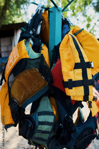 Colorful life vests hanging on hangers on beach