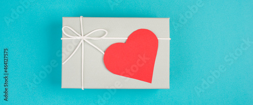 Gift box with a red heart, copy space for text, blue colored background, valintine day, birthday photo