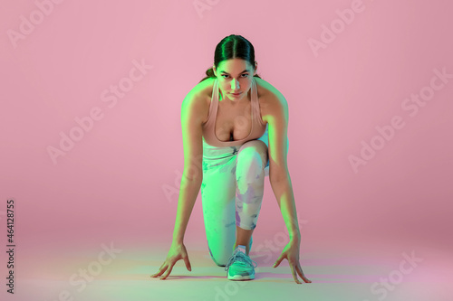 Sporty young woman in crouc...