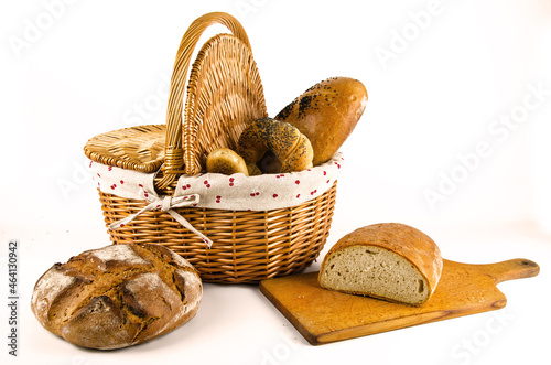 Basket with bread and whole wheat bread on white background. Sliced bread on board (ID: 464130942)