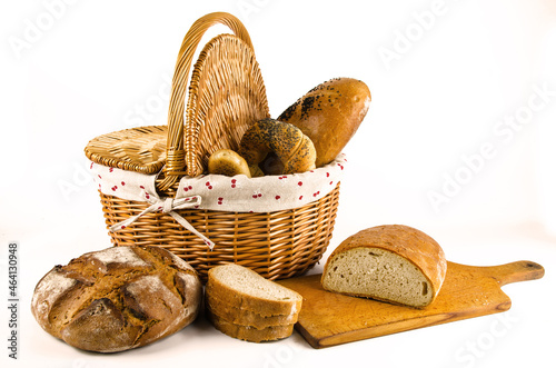 Basket with bread and whole wheat bread on white background. Sliced bread on board (ID: 464130948)