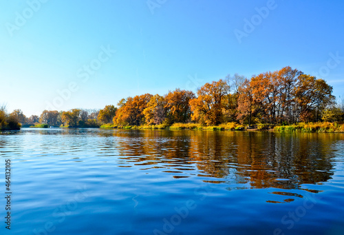 beautiful autumn landscape on the river orange trees reflected in the river selective focus