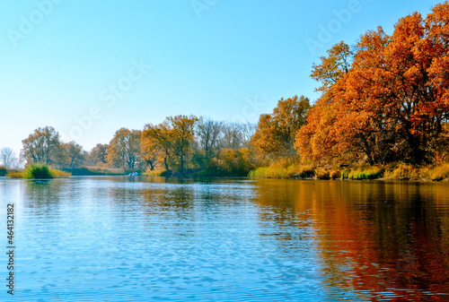 beautiful autumn landscape on the river orange trees reflected in the river selective focus