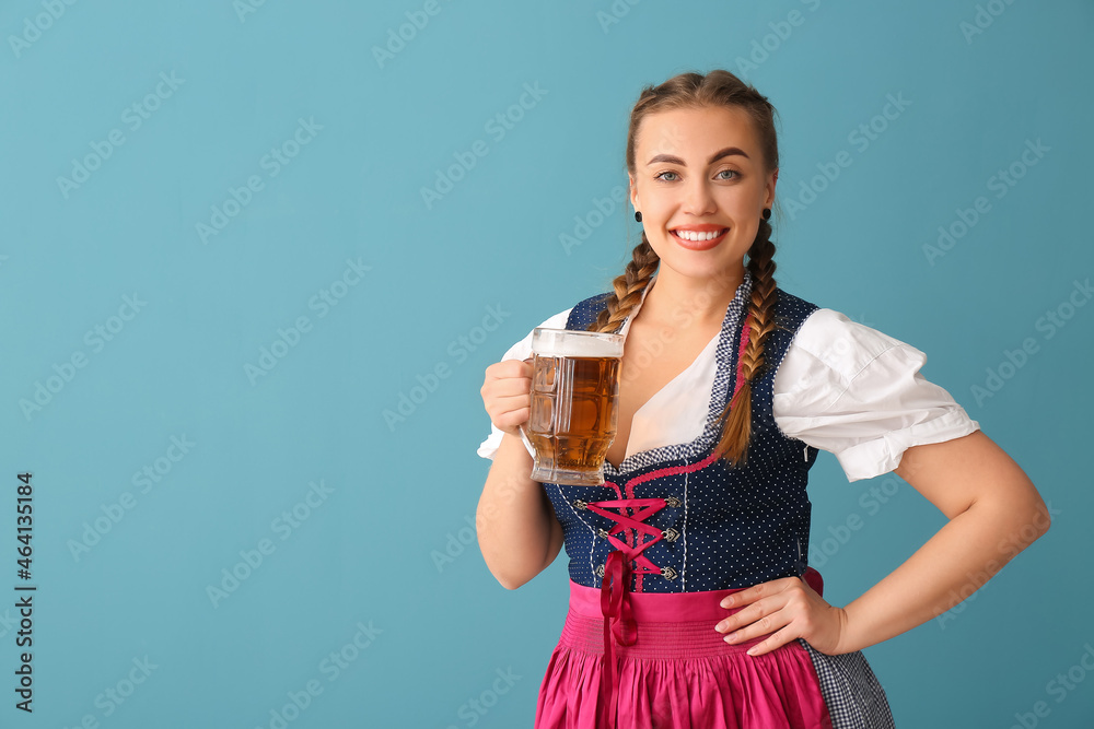 Young Octoberfest waitress with pale beer on blue background Young Octoberfest waitress with pale beer on blue background