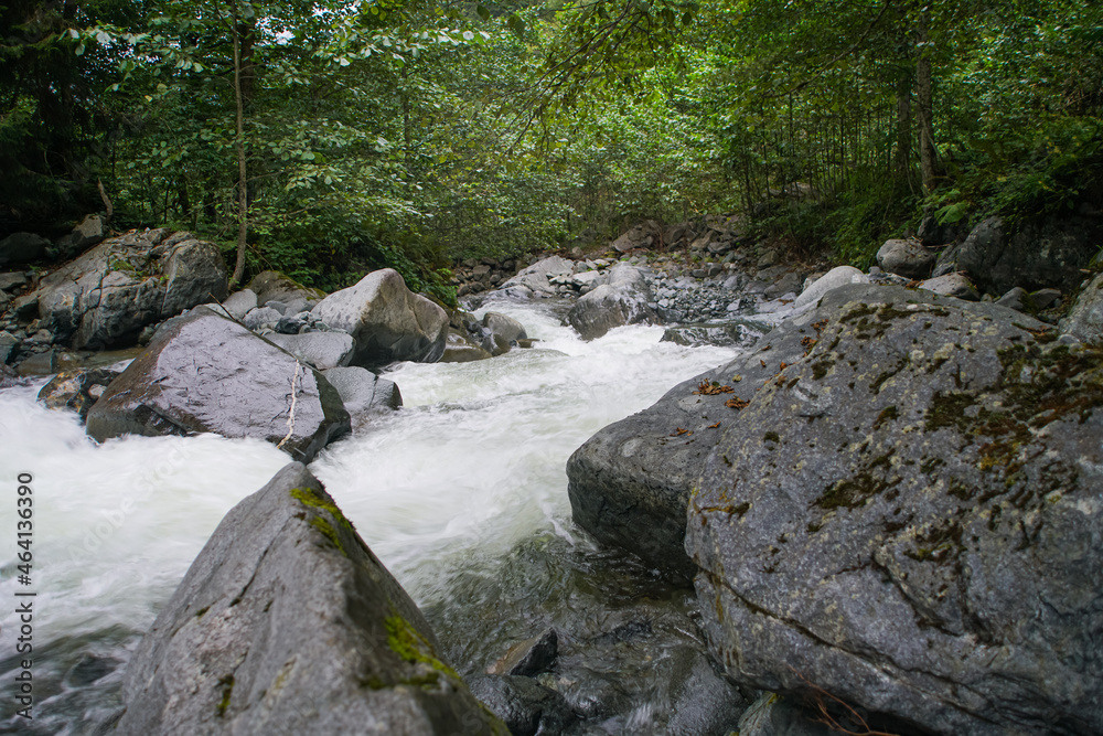 Clear mountain river , stream flowing through rocks. Close up of river stones with flowing water Clear mountain river , stream flowing through rocks. Close up of river stones with flowing water