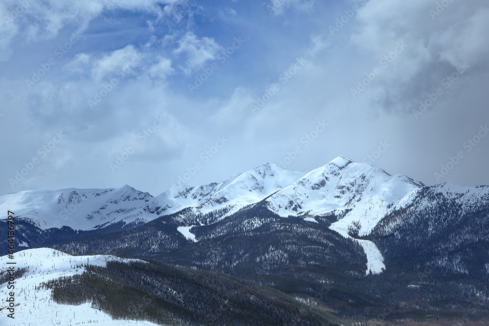 Snowy cloudy mountain peak landscape with evergreen tree forest in Arapaho National Forest, Colorado