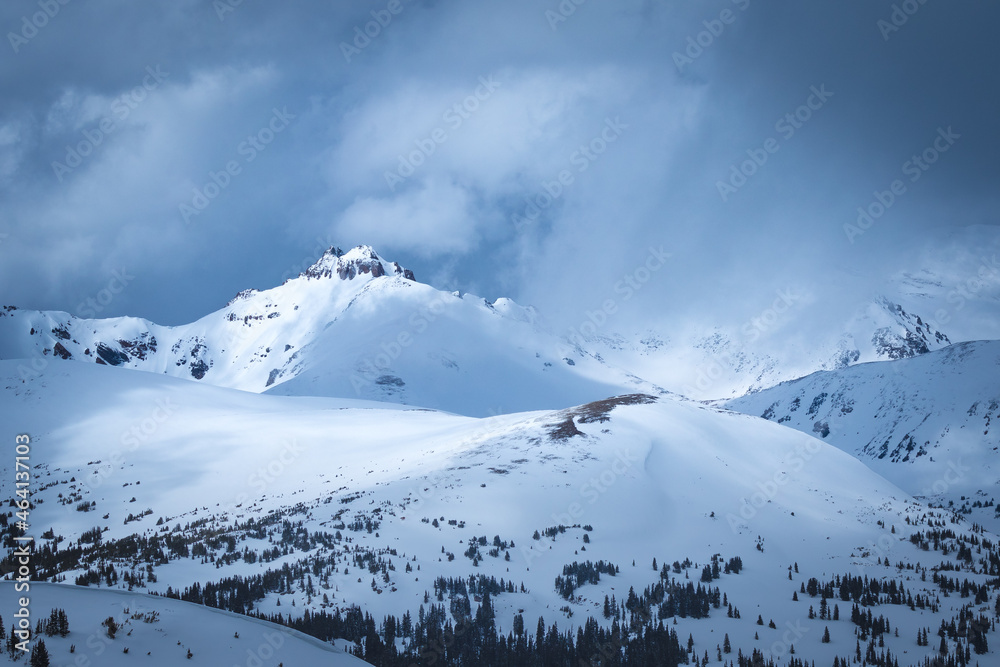 Snow covered mountain landscape with evergreen trees and dark clouds in Arapaho National Forest, Colorado Snow covered mountain landscape with evergreen trees and dark clouds in Arapaho National Forest, Colorado