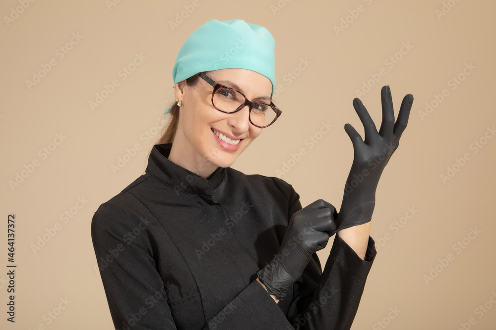 Smiling dentist putting on gloves Smiling dentist putting on gloves